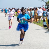 One girl running in a blue shirt and blue tutu